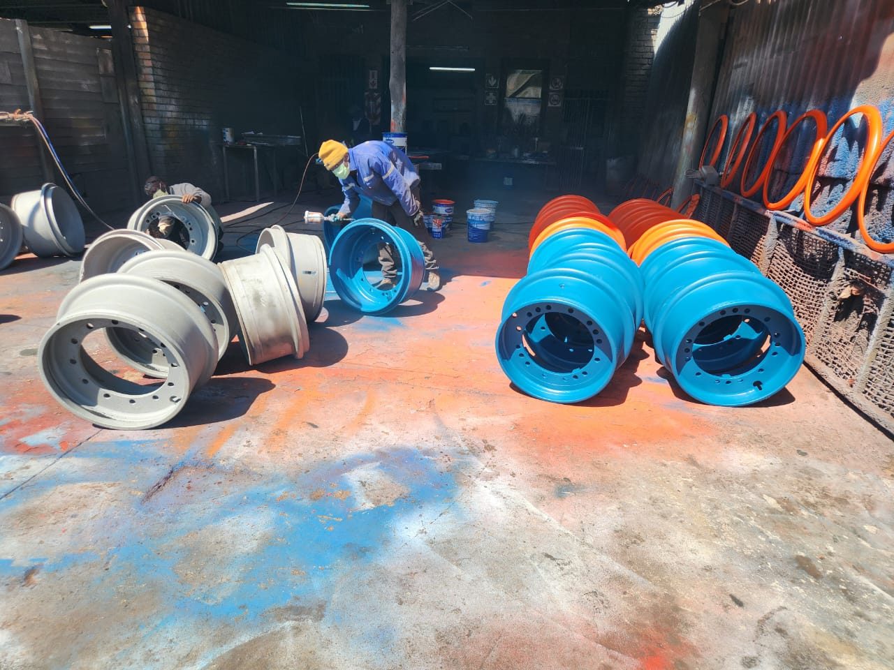 Heavy vehicle rims blasted and spray painted, bare rims alongside